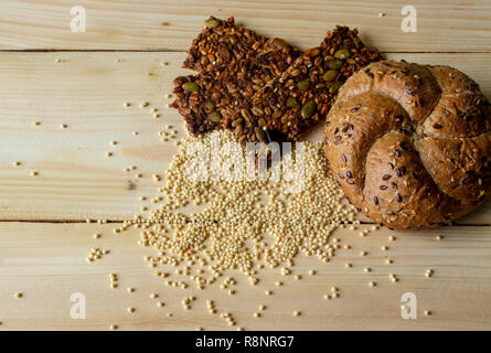 Granola, millet and buns of coarse flour on a wooden background close-up. The concept of healthy eating. Stock Photo