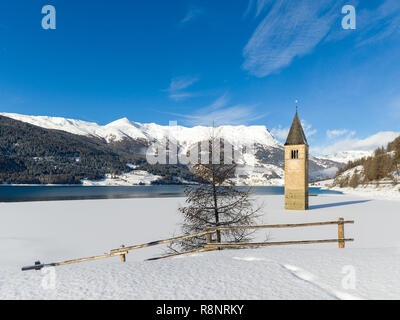 Sunken Church Tower in frozen lake near Graun on Resia Lake, South Tyrol Stock Photo