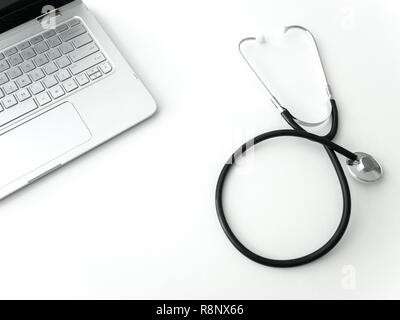 A doctors black flexible rubber and steel metal heart pulse stethoscope laying isolated on a white table top with laptop keyboard in upper corner maki Stock Photo