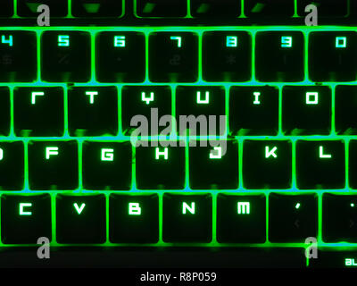 Black keyboard with green led. Colorful keyboard for gaming. Backlit keyboard with versatile color schemes. Colorful light keyboard. Stock Photo
