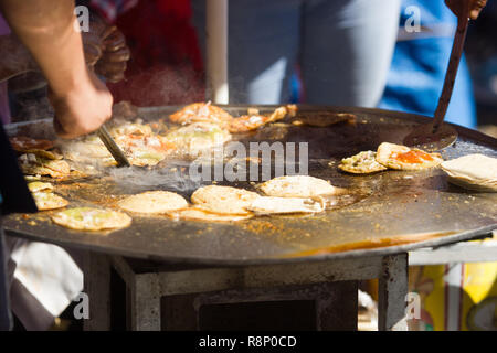 close up mexican street vendor cooking fry tacos with meat and sauce