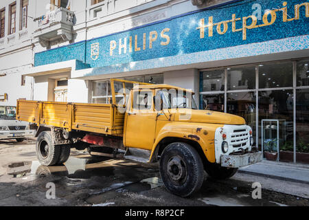 classic yellow American 1950s truck in front of old Mosaic Philips Hotpoint store sign in Havana, Cuba, Stock Photo