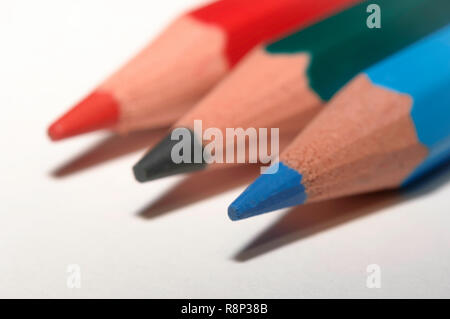 Macro of red green blue color pencils, all lined up on white paper. Stock Photo