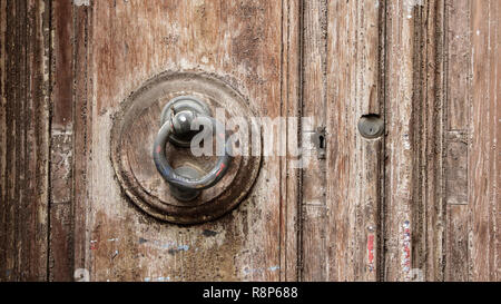 Close-up of an old handle on a brown wooden door Stock Photo