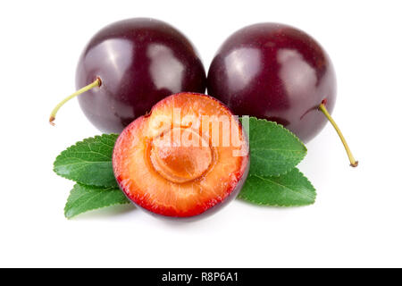Purple plums end half with leaves isolated on white background Stock Photo