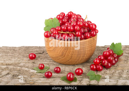Red currant berries in wooden bowl on wooden table with white background Stock Photo