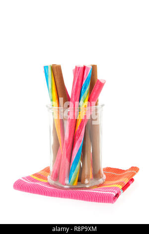 Glass pot of colorful candy canes isolated over white background Stock Photo