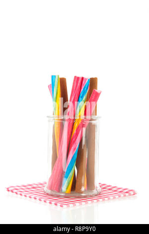 Glass pot of colorful candy canes isolated over white background Stock Photo