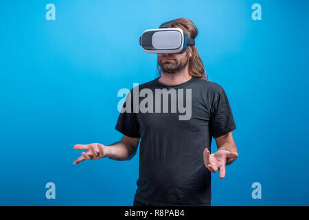 Male potrait wearing VR device looking confused. Virtual device simulator Stock Photo