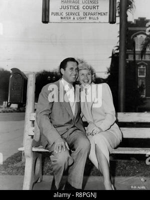 Doris Day, with her new husband, Marty Melcher, sitting on a bench beneath a sign for the county clerk's office, April 3, 1951  File Reference # 33635 641THA Stock Photo