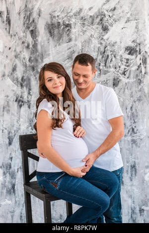 Pregnant couple hug and hold pregnant belly. Stock Photo