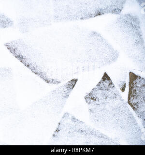Winter pavement background. Snow covered wild stone paving tiles. Stock Photo