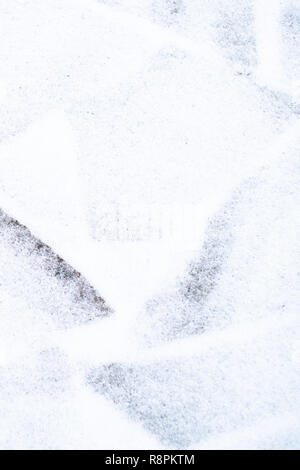 Winter pavement background. Snow covered wild stone paving tiles. Stock Photo