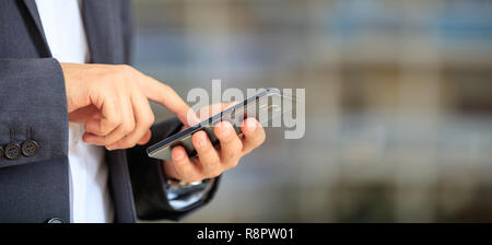 Man holding phone. Young businessman in business wear using a mobile, closeup view on smartphone, banner, copy space Stock Photo