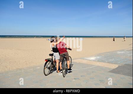 France, Nord, Dunkerque, Malo-les-Bains, seafront dike, bicycle couple posing for selfy Stock Photo