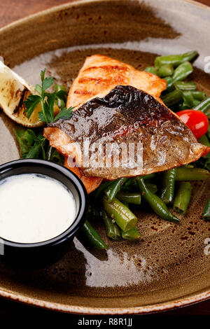 Grill Salmon Filet on Plate with Asparagus Sauce. Fresh Roasted Fish Steak Dish, Vegetables Tomato Serving in Restaurant. Healthy Lunch Concept Side V Stock Photo