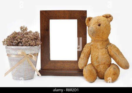 Wooden frame, Teddy bear and flower pot. Object over white Stock Photo