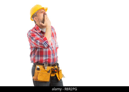 Sleepy builder covering mouth while yawning as tiresome hard work isolated on white studio background Stock Photo