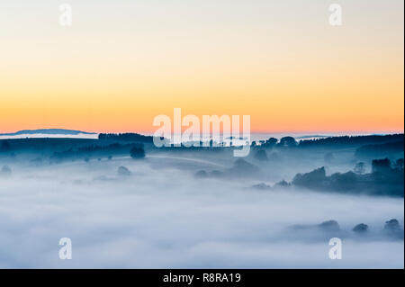 On the border between England and Wales near Knighton, Powys, UK. Evening view west from Stonewall Hill showing the valleys filled with thick fog Stock Photo