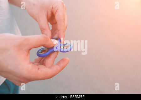 Young man holding and playing with fidget spinner. Stock Photo