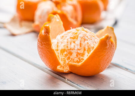 Fresh pieces of tangerines mandarin on wooden table. Stock Photo