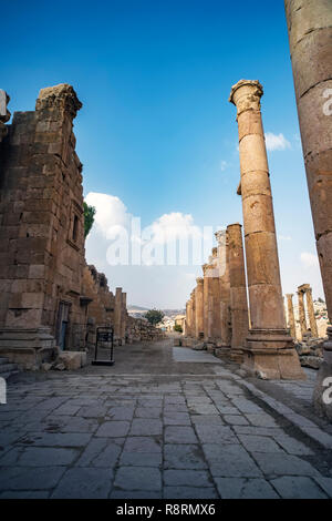 A view looking down the Cardo showing stone carved columns and paved street at the ancient city of Jarash or Gerasa, Jerash in Jordan. ancient Roman s Stock Photo