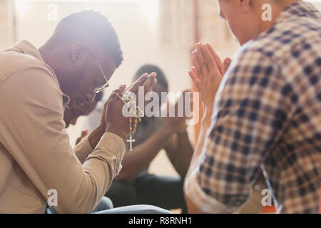 Men praying with rosary in prayer group Stock Photo