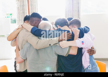 Men standing in huddle in prayer group Stock Photo
