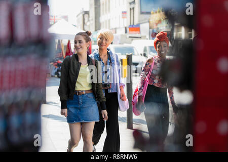 Young women friends walking on urban sidewalk Stock Photo