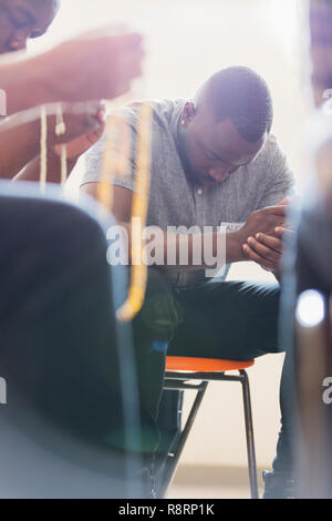 Man praying in prayer group Stock Photo