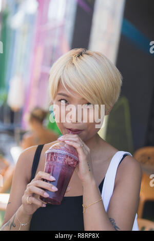 Portrait smiling young woman drinking smoothie Stock Photo