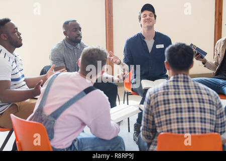 Men praying with bibles in prayer group circle Stock Photo