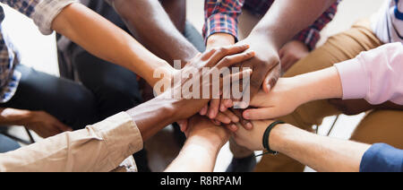 Men joining hands in group therapy Stock Photo