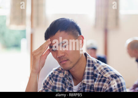 Frustrated man with head in hands Stock Photo