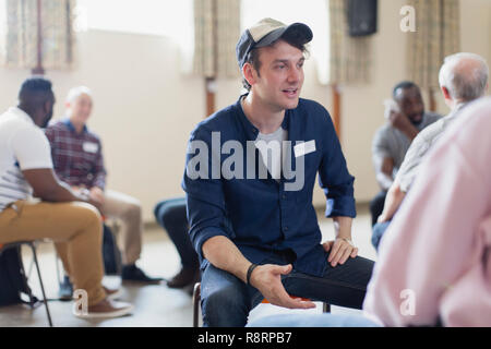 Young man talking in group therapy in community center Stock Photo