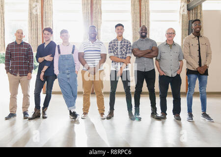 Portrait confident men standing in a row in community center Stock Photo
