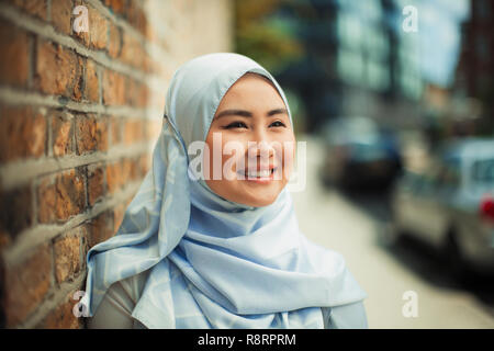Portrait smiling, confident young woman in blue silk hijab Stock Photo