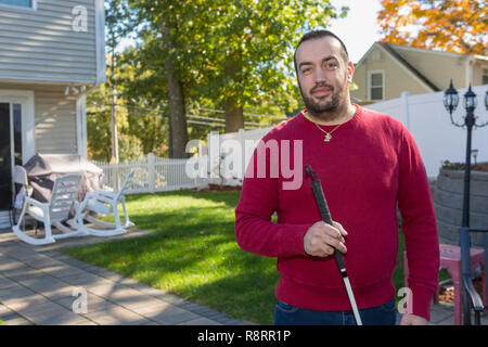 Man with Visual Impairment using his cane outdoors Stock Photo