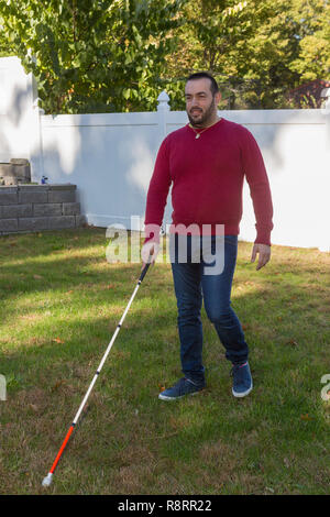Man with Visual Impairment using his cane outdoors Stock Photo