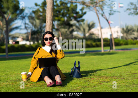Girl working on laptop in the park outside of the office Stock Photo