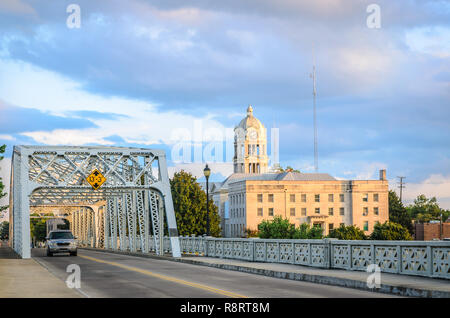 A car drives across Keesler Bridge, which spans the Yazoo River in Greenwood, Mississippi. In the background is the Leflore County Courthouse. Stock Photo