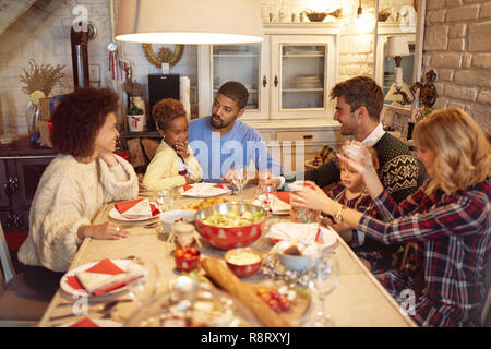 Smiling friends have fun at a family Christmas dinner Stock Photo