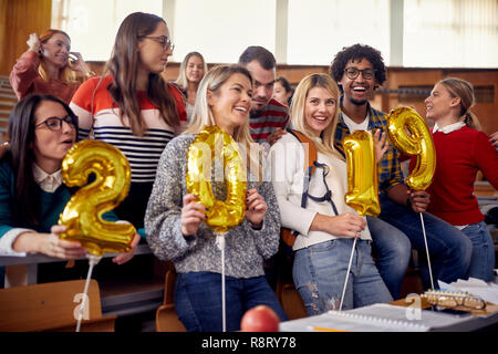 Group of happy colleagues having fun at new year celebration on university Stock Photo
