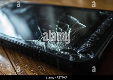 Cracked touch screen on Smartphone on wooden table Stock Photo