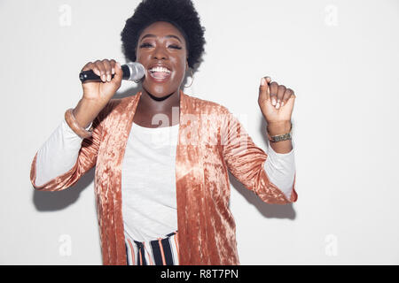 Portrait young woman with microphone singing Stock Photo