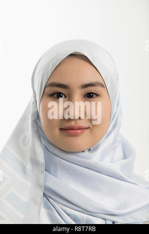 Portrait smiling, confident young woman in blue silk hijab Stock Photo