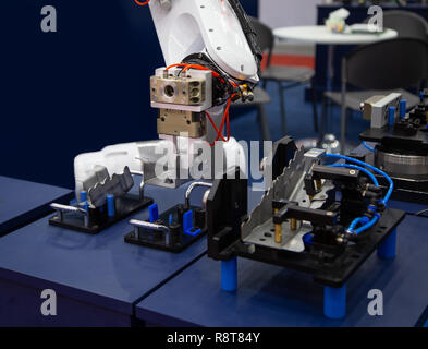 Industry automated robot arm loading and unloading workpieces in production line Stock Photo