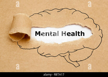 Text Mental Health appearing behind torn brown paper with drawn human brain on it. Stock Photo