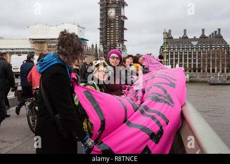 London, UK. 18th December, 2018. Activists from around the UK drop a banner from Westminster Bridge in solidarity with the Stansted 15 and all migrants on International Migrants Day. The Stansted 15 were convicted on 10th December of an anti-terrorism offence under the Aviation and Maritime Security Act 1990 following non-violent direct action to try to prevent a Home Office deportation flight carrying precarious migrants to Nigeria, Ghana and Sierra Leone from taking off from Stansted airport in March 2017. Credit: Mark Kerrison/Alamy Live News Stock Photo