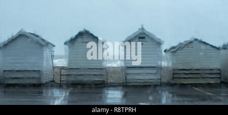 Lyme Regis, Dorset, UK. 18th December 2018.  UK Weather: A Wet and windy day at Lyme Regis.  Wet beach huts on Monmouth Beach as heavy downpours hit the coast at Lyme Regis.  A Yellow Warning of rain has been issued along the South West Coast. Credit: PQ Images/Alamy Live News Stock Photo